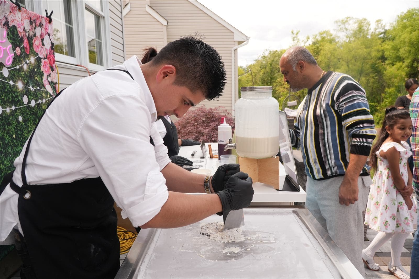 Rolling ice cream fresh on the frozen griddle at an outdoor event