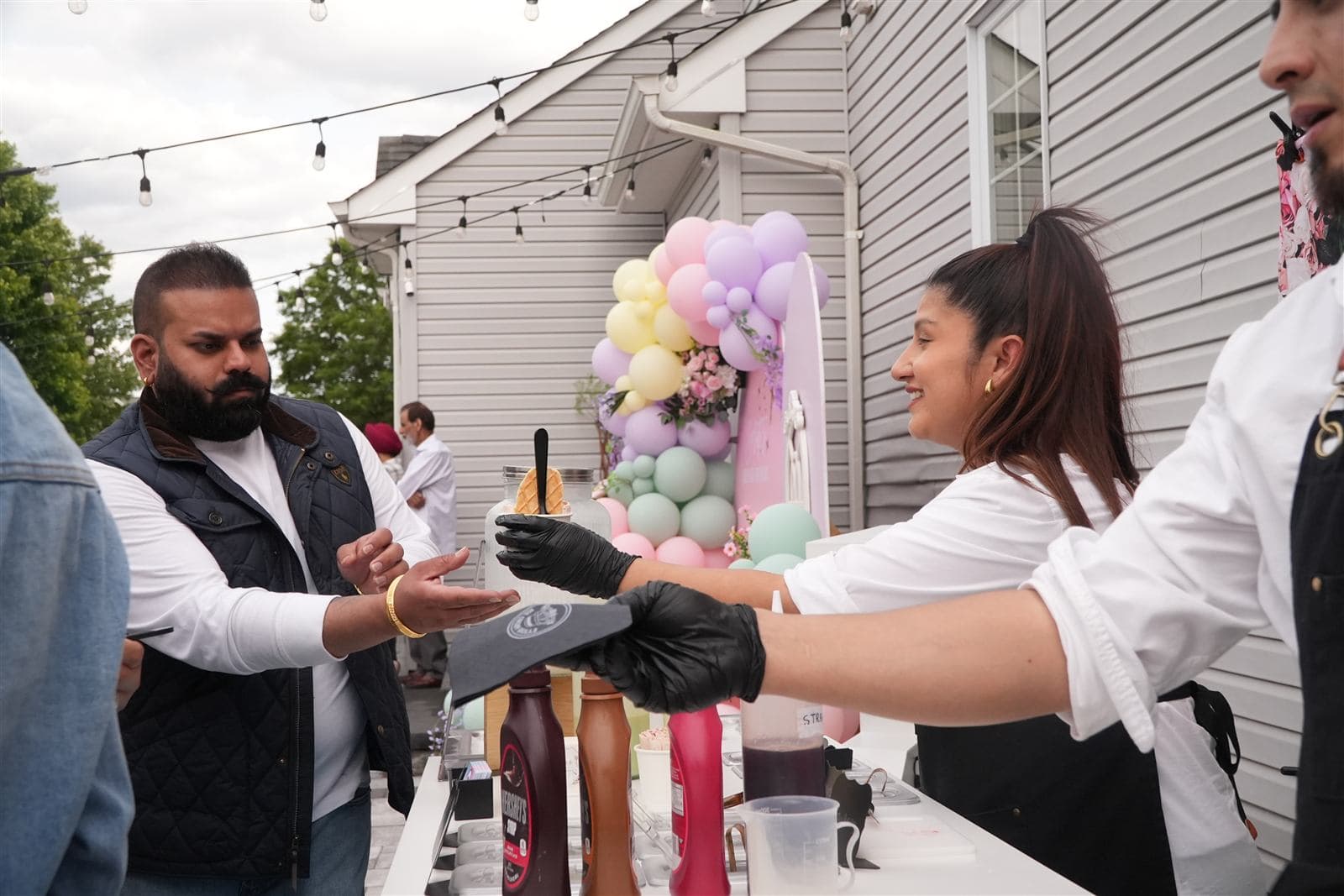 Serving fresh ice cream rolls to guests at an outdoor celebration