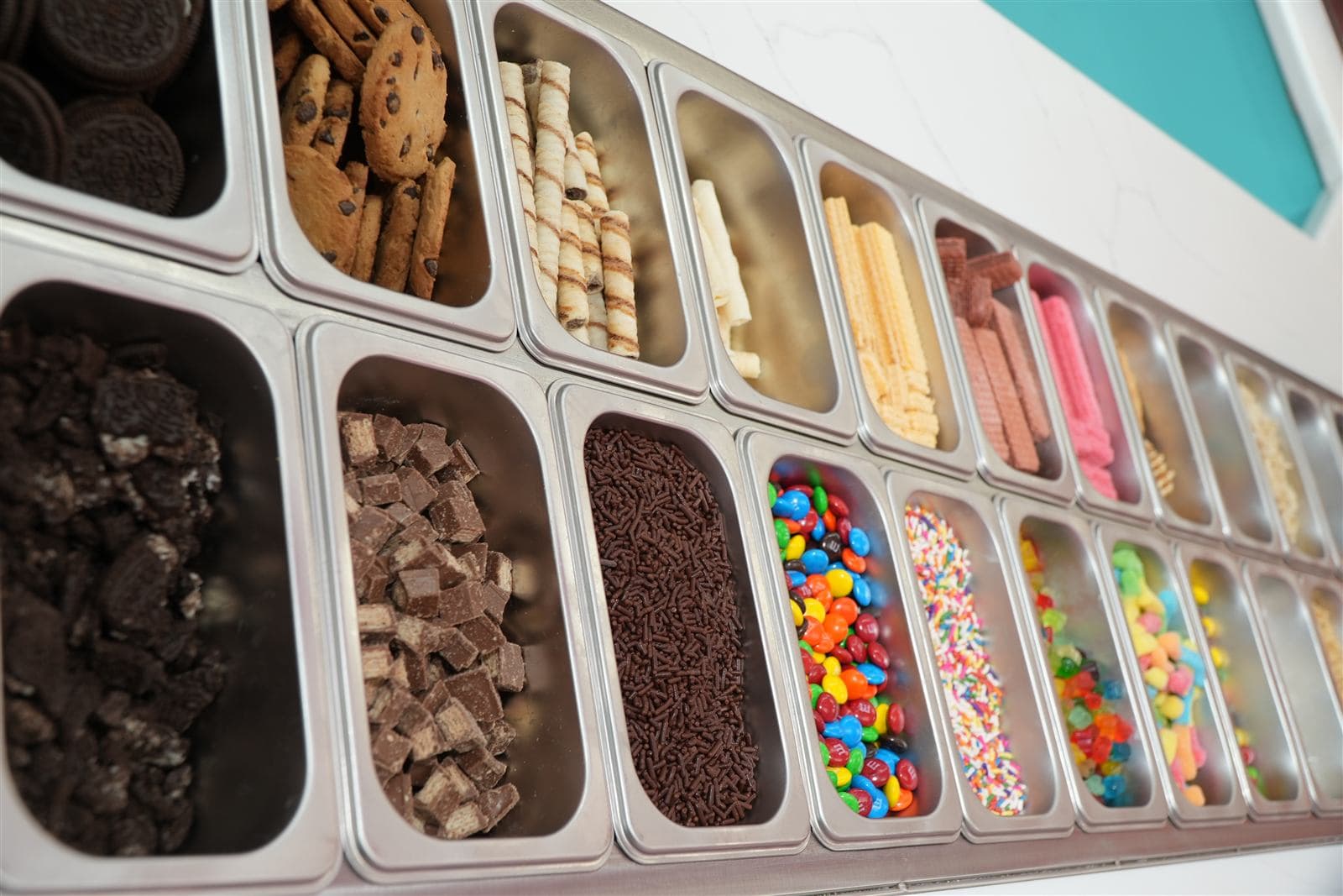 Rollitos topping bar filled with cookies, wafers, candies, and sprinkles