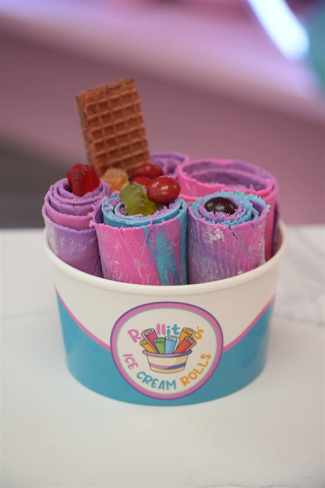 Unicorn ice cream rolls with gummy candies and a chocolate wafer